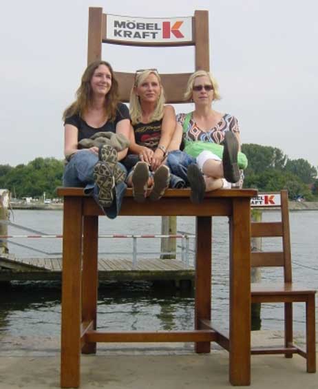 Auf dem großen Stuhl neben dem Anleger der Norderfähre sitzen Tina (li., 35), Ruth (37) und Natja (35). Foto: WOLFGANG MOEBIUS