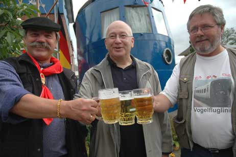 Anstoßen auf die »Vogelfluglinie«. Lokführer Hans Potratz aus Kücknitz, Zugchef Jochen Grochowina aus Hamburg und der Lokführer der Dänischen Staatsbahn (DSB) Erling Laursen (r.). Sprachprobleme gibt es übrigens nicht: Alle Dänen der Vogelfluglinie sprechen Deutsch, die Deutschen Mitarbeiter alle Dänisch. Früher wurde gemischt gefahren, erst seit anderthalb Jahren wechselt das Personal an der Grenze. Foto: RD
