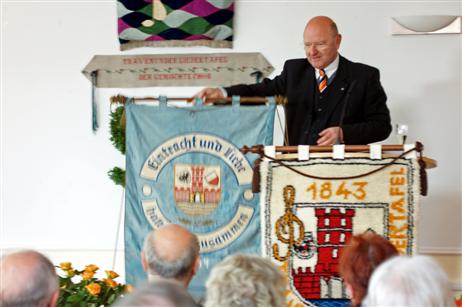 Der Vorsitzende des Gemeinnützigen Vereins zu Travemünde und Vorsitzender des Ortsrates, Richard Schrader, überbringt nach seinen Glückwünschen an das Geburtstagskind die Traditionsfahne des ehemaligen Travemünder Gesangvereins »Eiche« aus dem Jahre 1911. 