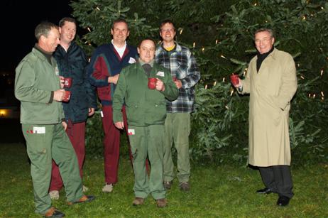 Rosenhofdirektor Reiner Hülsebusch mit seinen Gärtnern beim traditionellen Weihnachtspunschtrinken nach getaner Arbeit vor einem der beiden Weihnachtsbäume. 