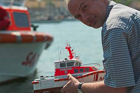 Modellbauer Jörg Müller-Drenkberg holt für eine Überprüfung auf Wassereinbruch das kleine Modell an Land, weil eine vorbeifahrende Ostsee-Fähre sehr hohe Wellen verursacht hat. Foto: Karl Erhard Vögele