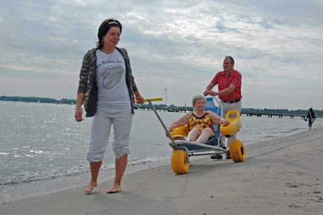 Maren Roschkowski von der Strandkorbvermietung Seipel und Kurdirektor Uwe Kirchhoff auf Testfahrt mit Urlauberin Hannelore Kind. Foto: TA
