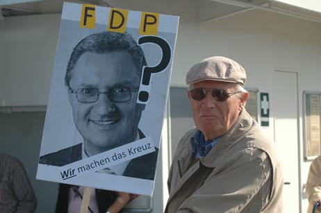 Politiker-Köpfe auf Transparenten, hier Thomas Schalies (FDP) begleiteten die Demonstration. Foto: TA 
