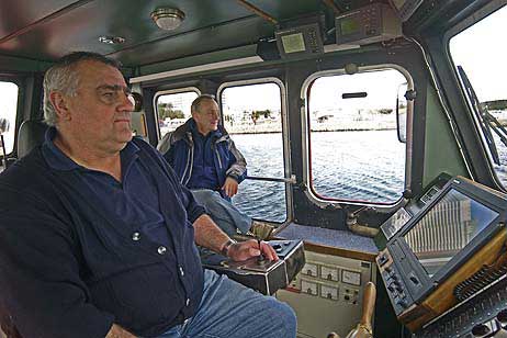 Schiffsführer des Lotsenbootes »Travemünde« Christian Sehmel (li) mit Seelotse Wolfgang Meyer (re) an Bord, passieren gleich die Mole in Travemünde auf der Fahrt zur MIR.