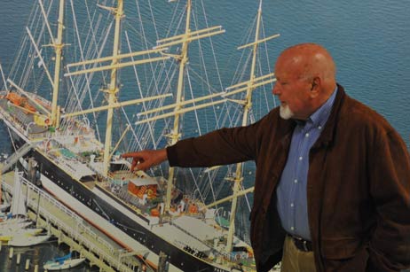 Auf dem großformatigen Bild der Viermastbark Passat, eine neuzeitliche Aufnahme von Karl Erhard Vögele, kann Ingo Petersen von der Passat-Stiftung gut die Aufbauten des Schiffes erklären. Die Stiftung verfügt aus Nachlässen über ein Kapital von 145.000 Euro. Aus den Erträgen würde die hölzerne Skulptur »Fiete« vor der Passat, die aktuelle Ausstellung und demnächst ein englischsprachiges Buch über die Passat finanziert. Foto: TA 