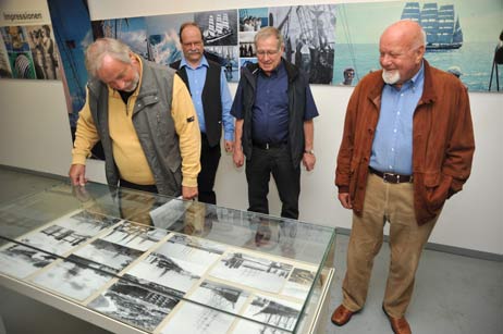 Rolf Fechner, Dr. Wolfgang Muth, Hartmut Haase und Ingo Petersen begutachten historische Fotos von der Überführung der Passat von Hamburg nach Travemünde. Foto: TA 