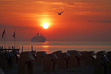 Travemünder Motive: Kreuzfahrt-Schiff im Sonnenaufgang vor Strandkorb-Kulisse. Fotos: KARL ERHARD VÖGELE
